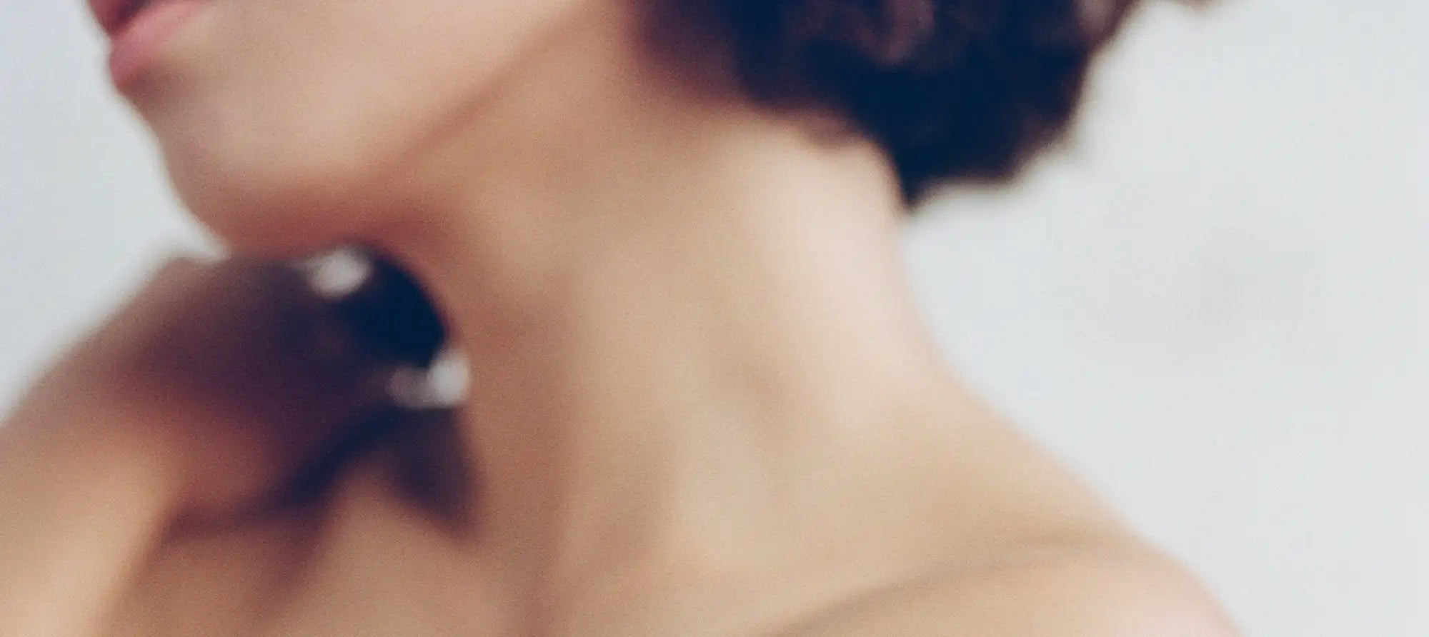 A sleek, black and silver necklace with a modern geometric design rests elegantly against the model’s neck.
